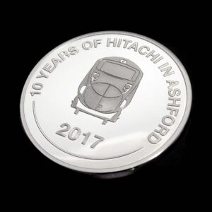 Hitachi Rail Europe 10 Years in Ashford commemorative coin in silver semi-proof finish, featuring a detailed train engraving and anniversary inscription. A bespoke corporate commemorative coin created to celebrate a decade of innovation, investment and achievement in rail engineering and transportation.